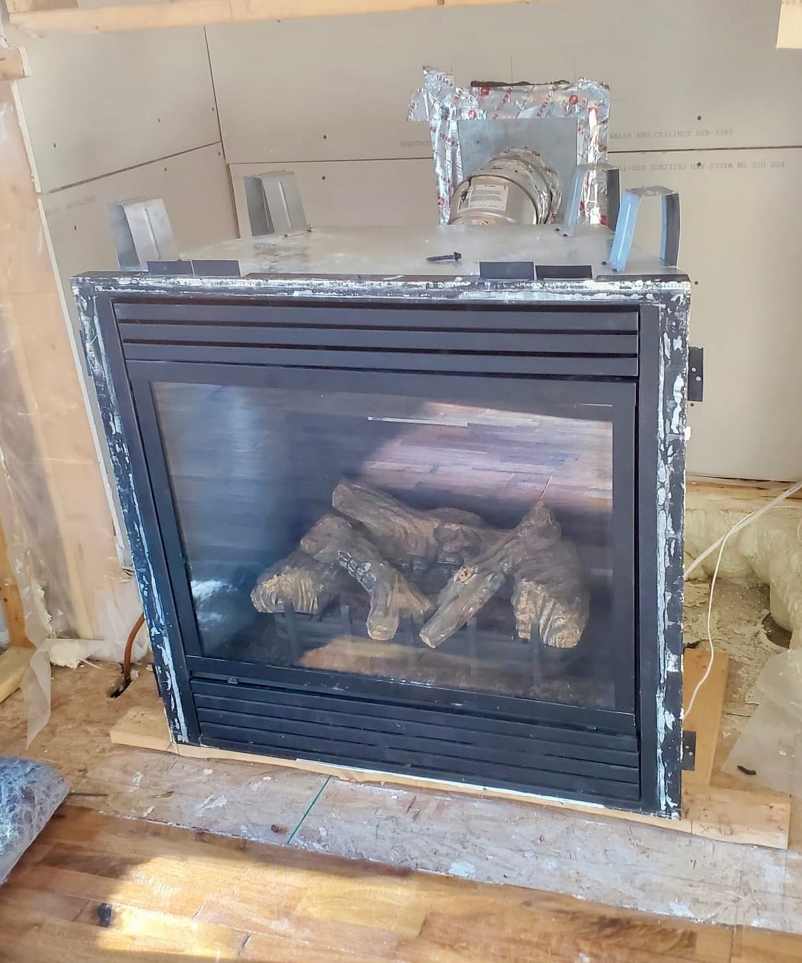 Double-sided see-through gas fireplace during installation with framing visible